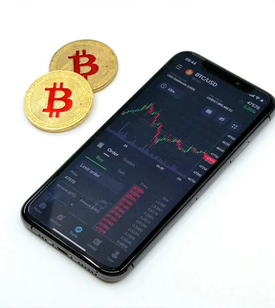 Smartphone displaying a cryptocurrency trading app with Bitcoin symbols and price charts